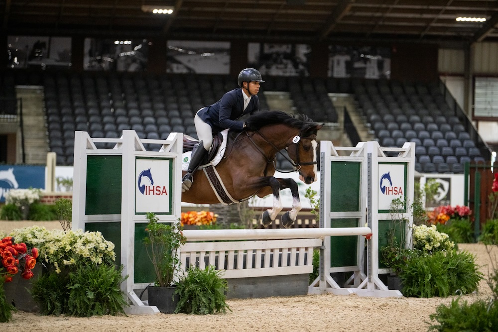 Young black man on a horse jumping in a competition